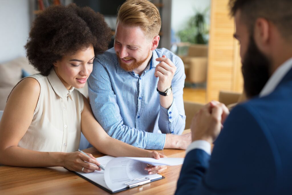 Couple smiling as they sign mortgage documents