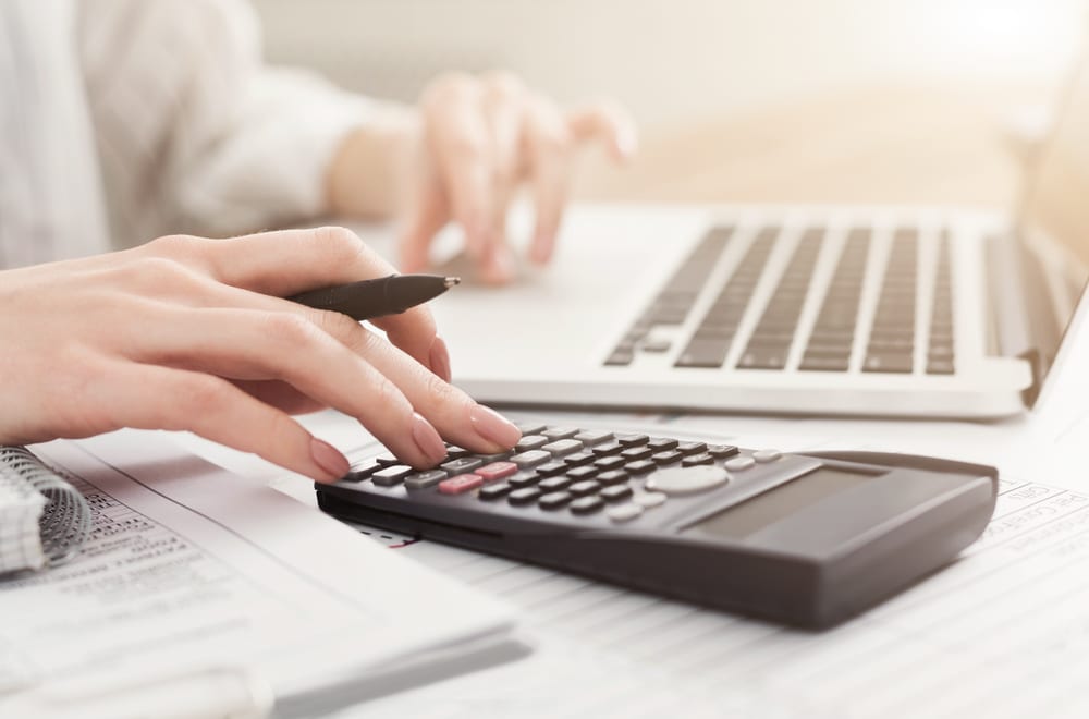 Woman calculating numbers to see if she can pay off her mortgage early