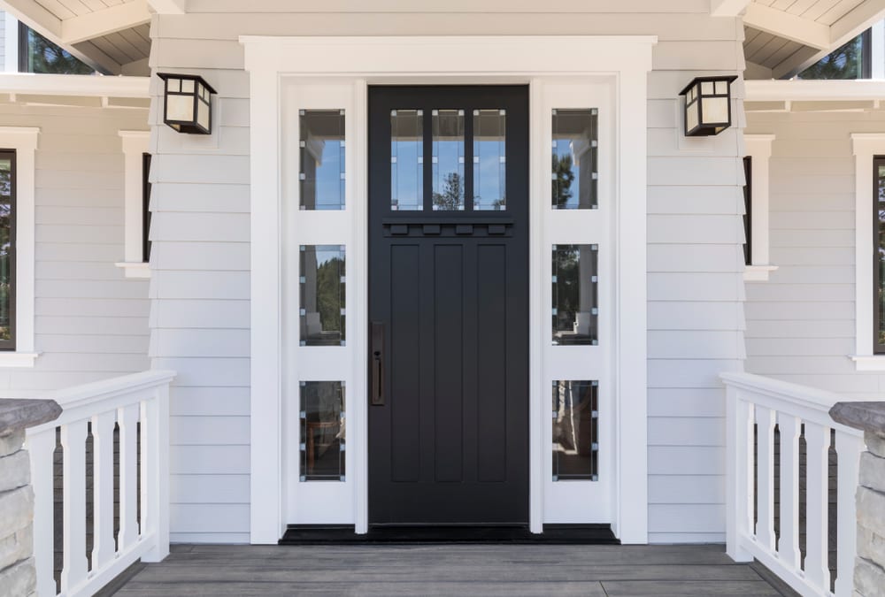 Black front door with white frame and white siding