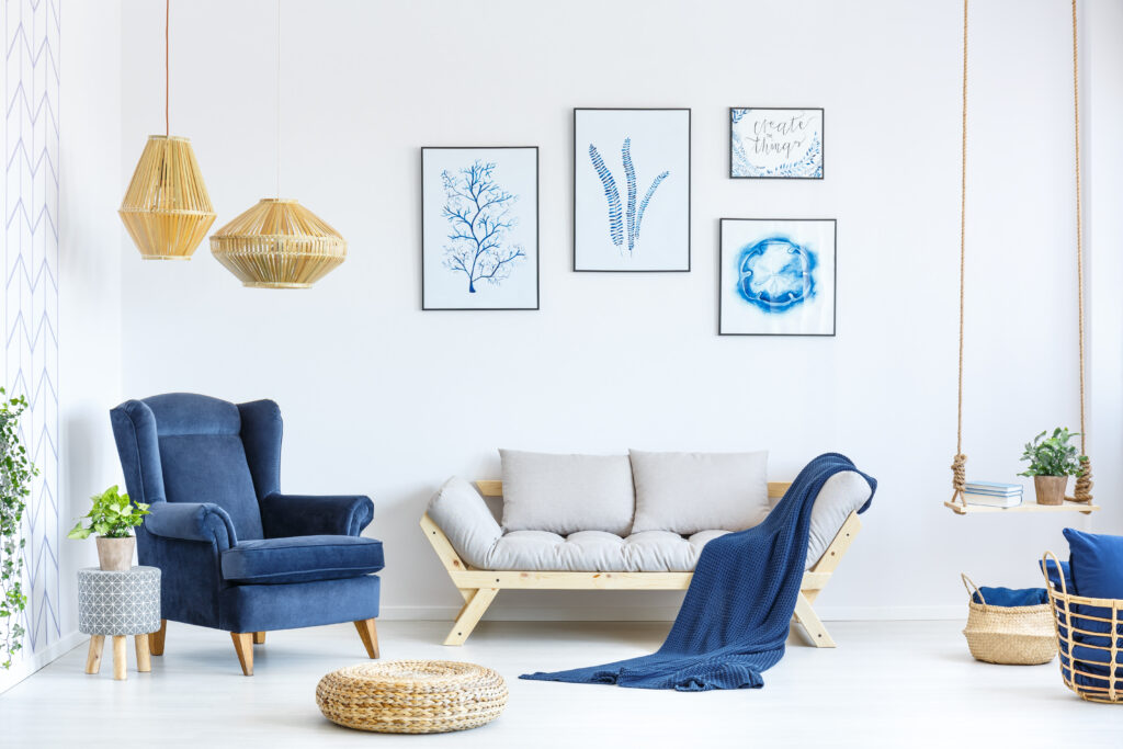 White and blue living room with sofa, armchair, lamp, posters