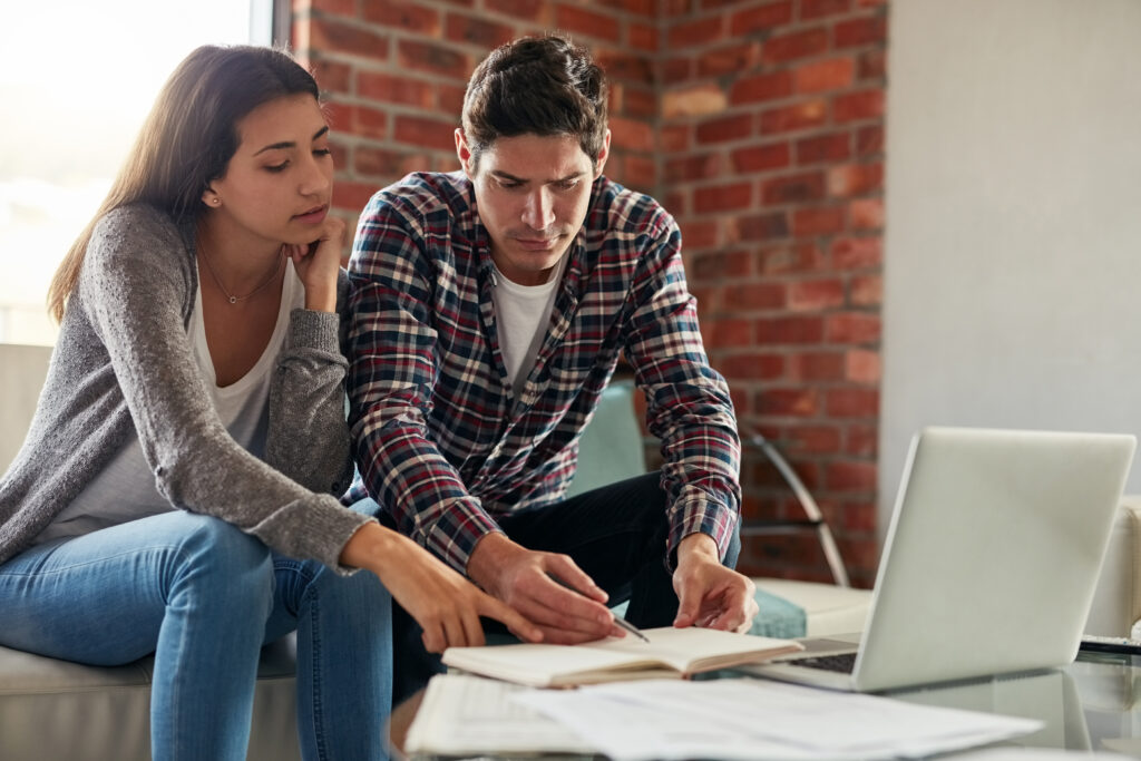 Shot of a couple looking stressed while working through paperwork