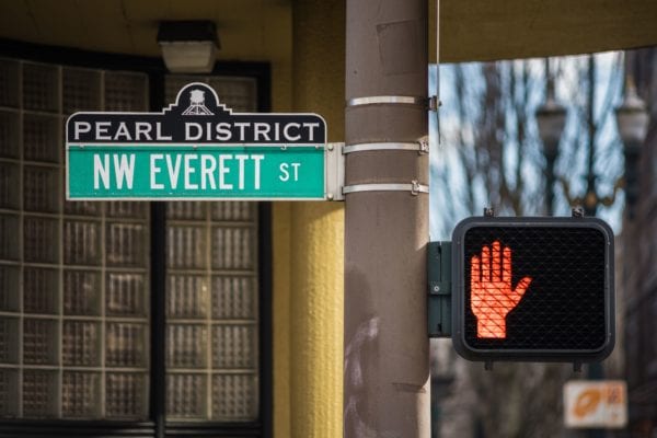 Sign of Pearl District in Oregon with Everett street and stop hand traffic light for pedestrians