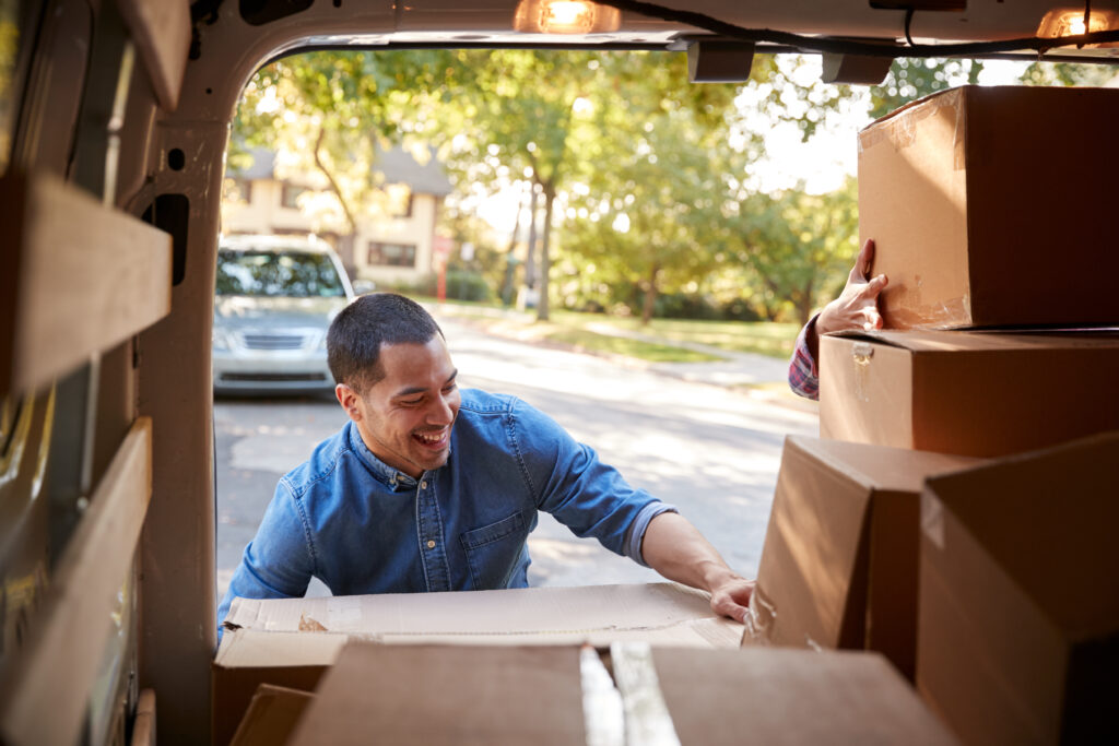 Man unpacks boxes from moving van