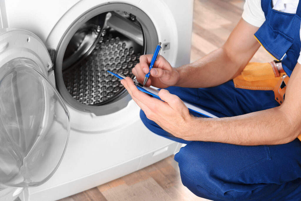 Repairman with clipboard next to washing machine