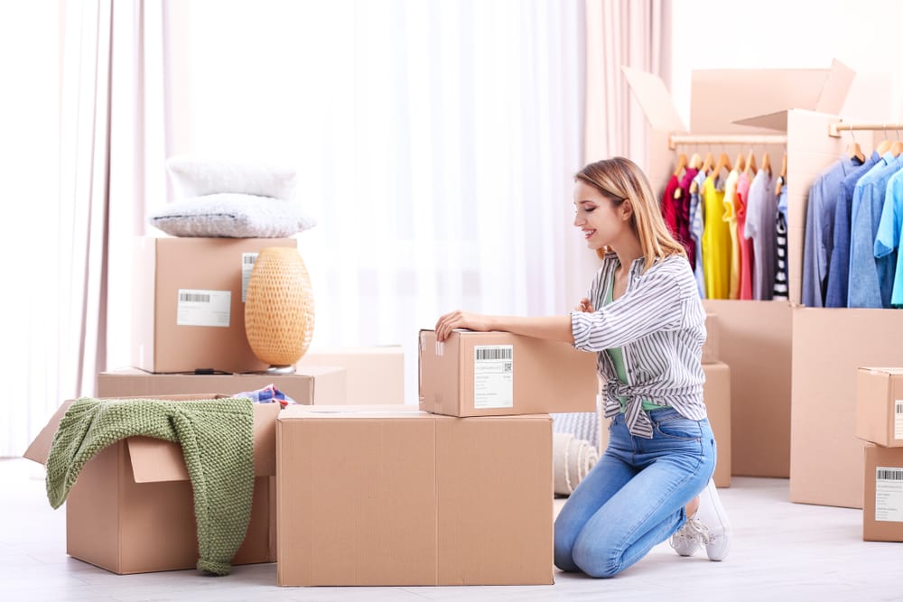 A young woman packs her closet for her upcoming move