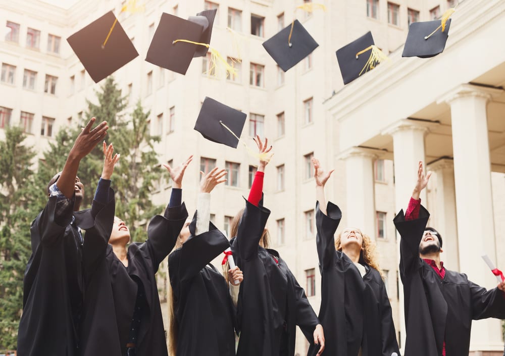 Graduates throw their caps into the air