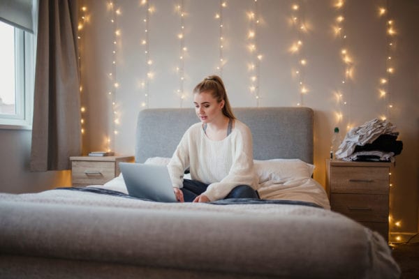 Young woman with twinkle lights in her dorm room