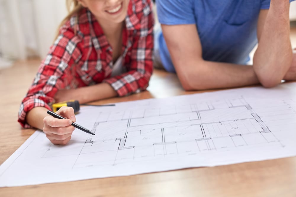 Husband and wife look over blueprints for an upcoming remodel