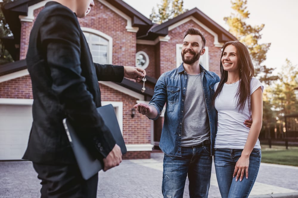 Couple stands in front of their dream house