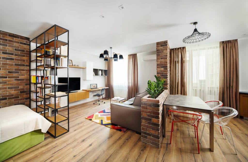 Interior studio apartments, with bookshelves and hardwood floors.