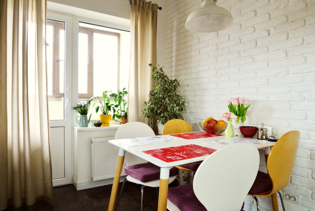 Interior of the kitchen in Scandinavian style with white furniture and a dining table