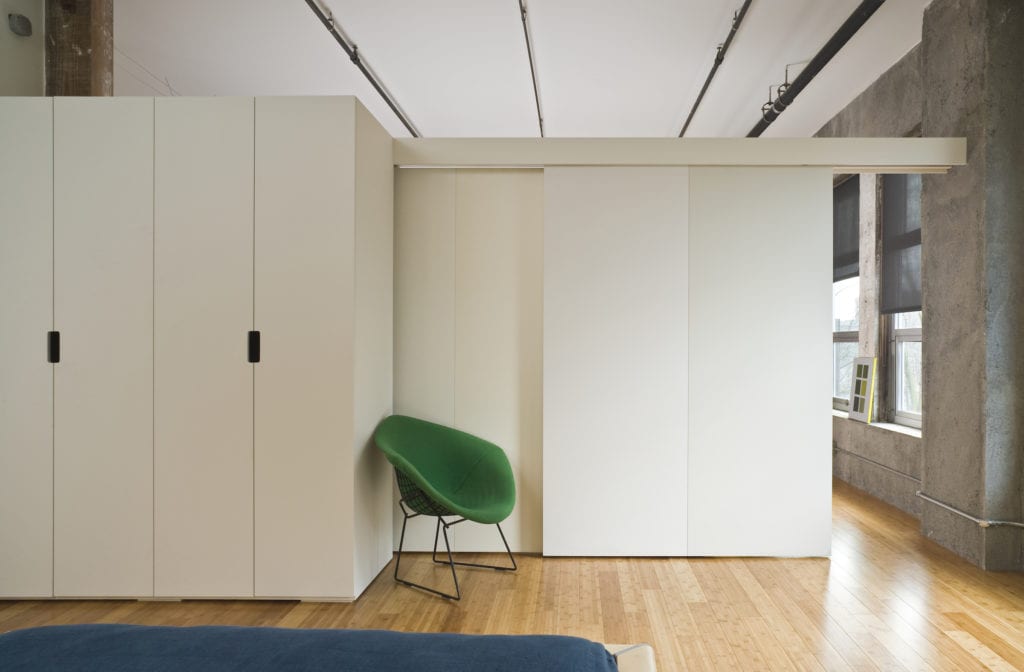 Modern style bedroom interior with room divider separating it from the rest of the loft. Horizontal shot.