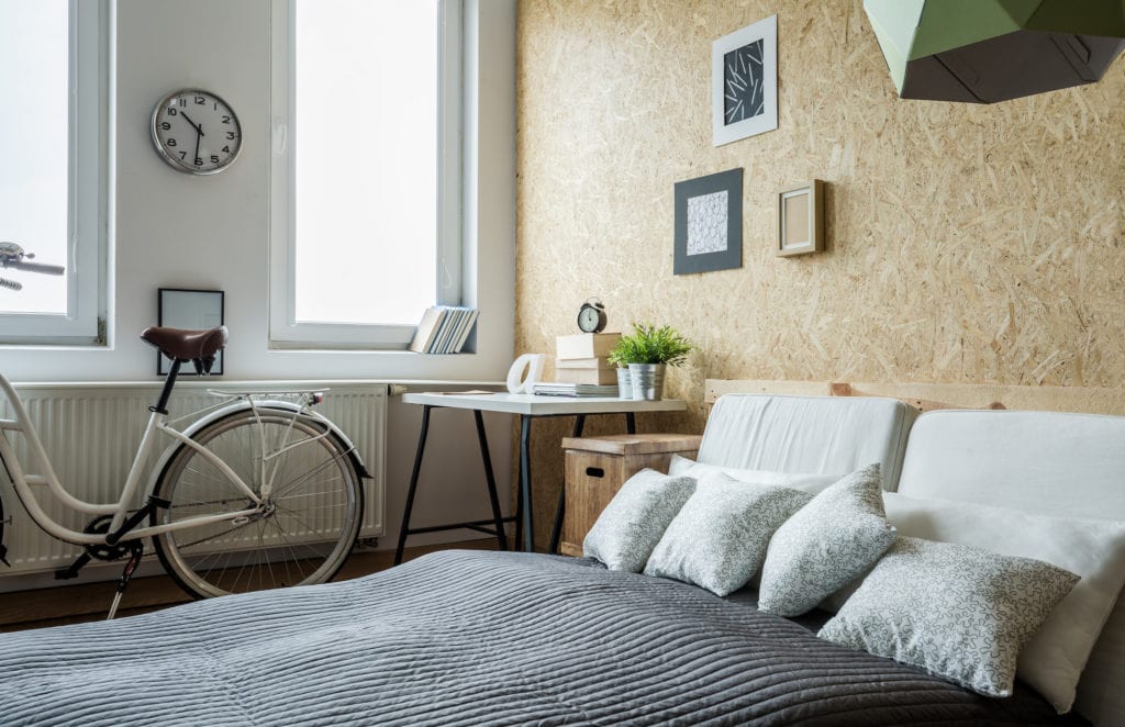 White city bicycle in bedroom with wooden wall