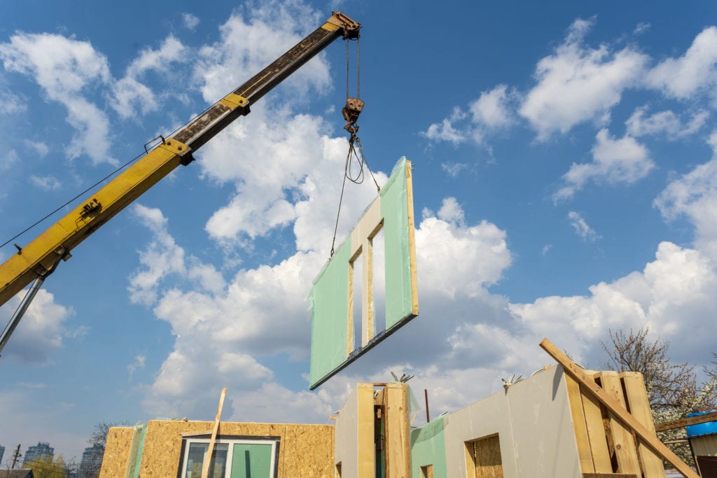 A crane is piecing together a modular or prefabricated home