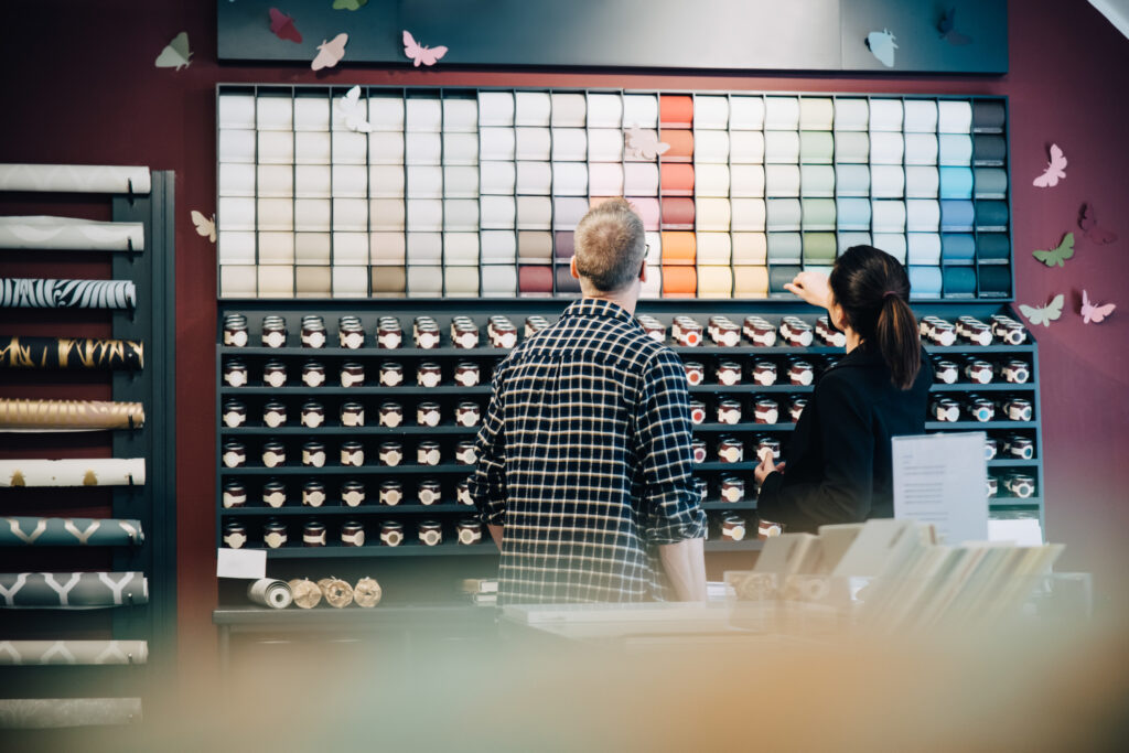 Male sales rep helps a woman choose the right paint color