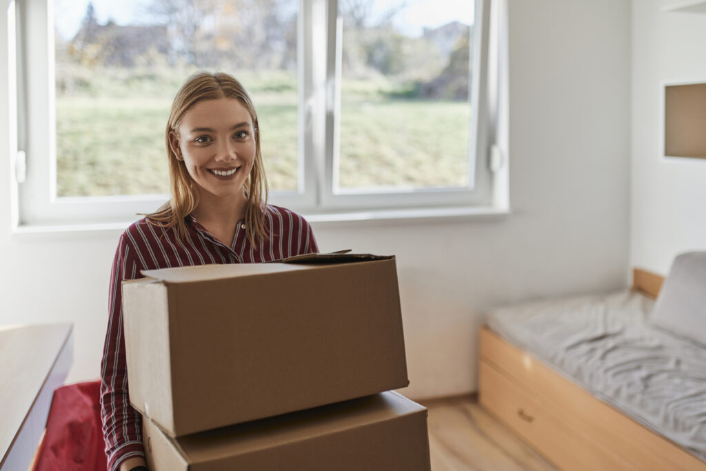 Young woman moving into college dorm