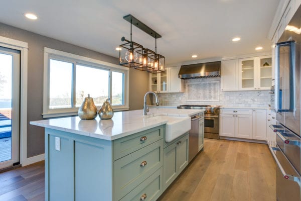 Kitchen with mint green island and stainless steel appliances