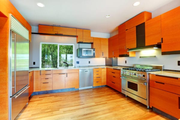 Modern kitchen with orange cabinets and steel appliances