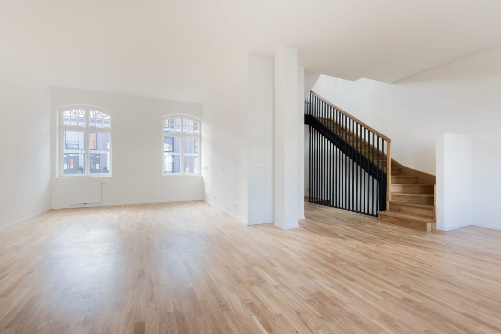 Empty home with reclaimed hardwood floors and wood staircase