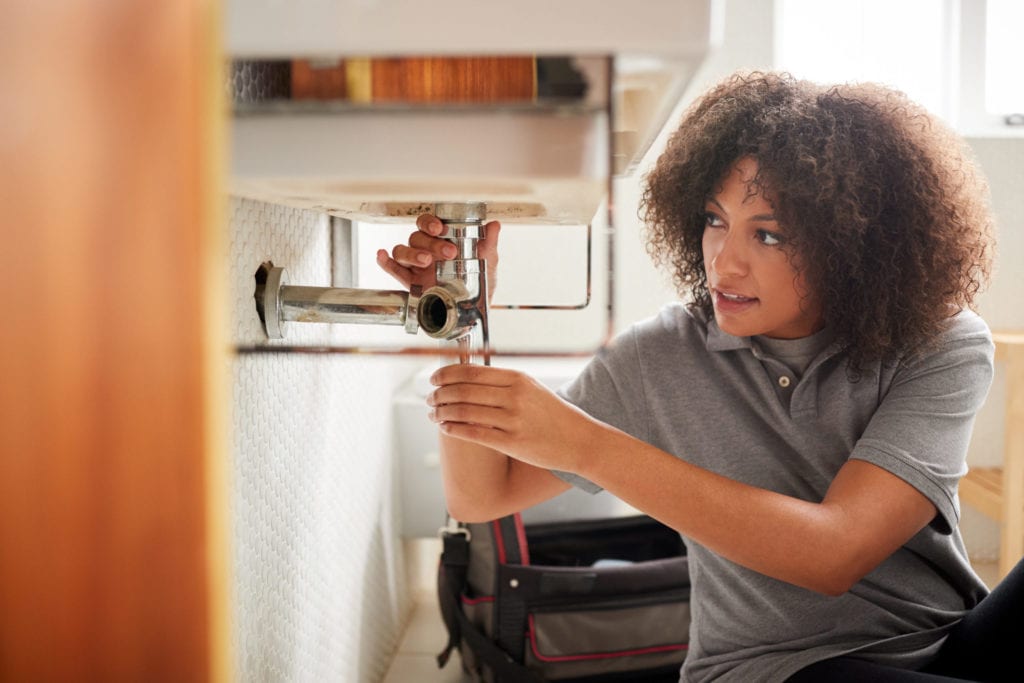 woman fixing sink