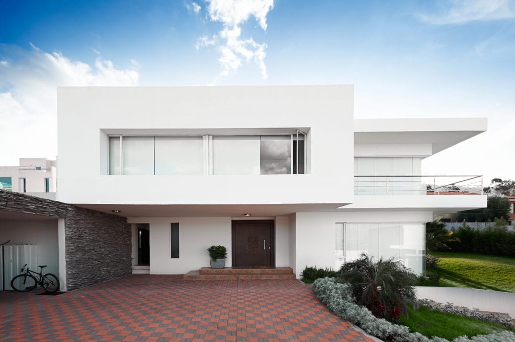 Modern white house exterior with checkered paved driveway