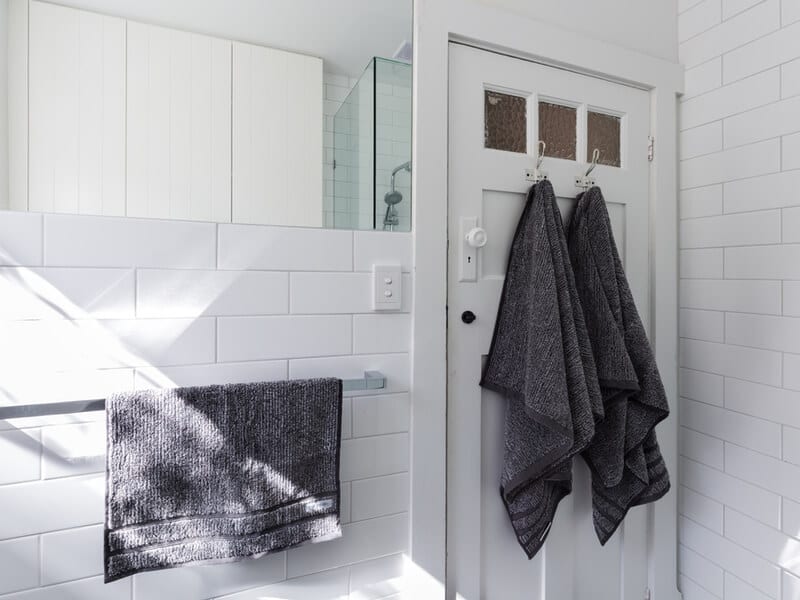 White bathroom with towels on the door 