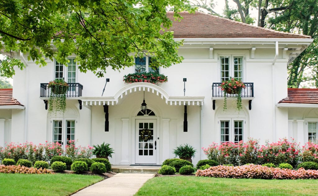 White house exterior with pink flowers and beautiful landscaping