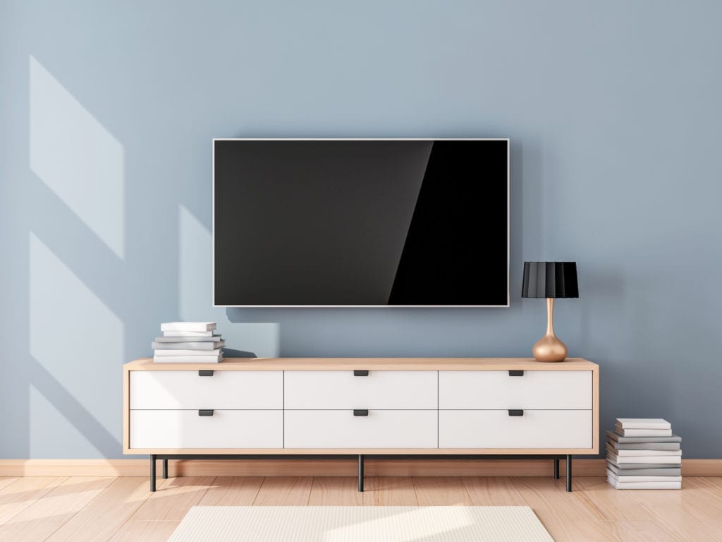 Modern TV and TV stand against blue wall in living room