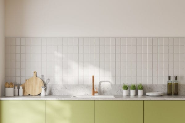 Green kitchen cabinets against modern gray tile backsplash