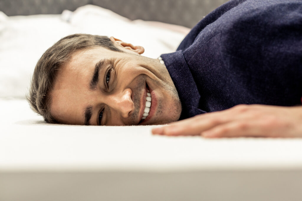 Man lies on a memory foam mattress