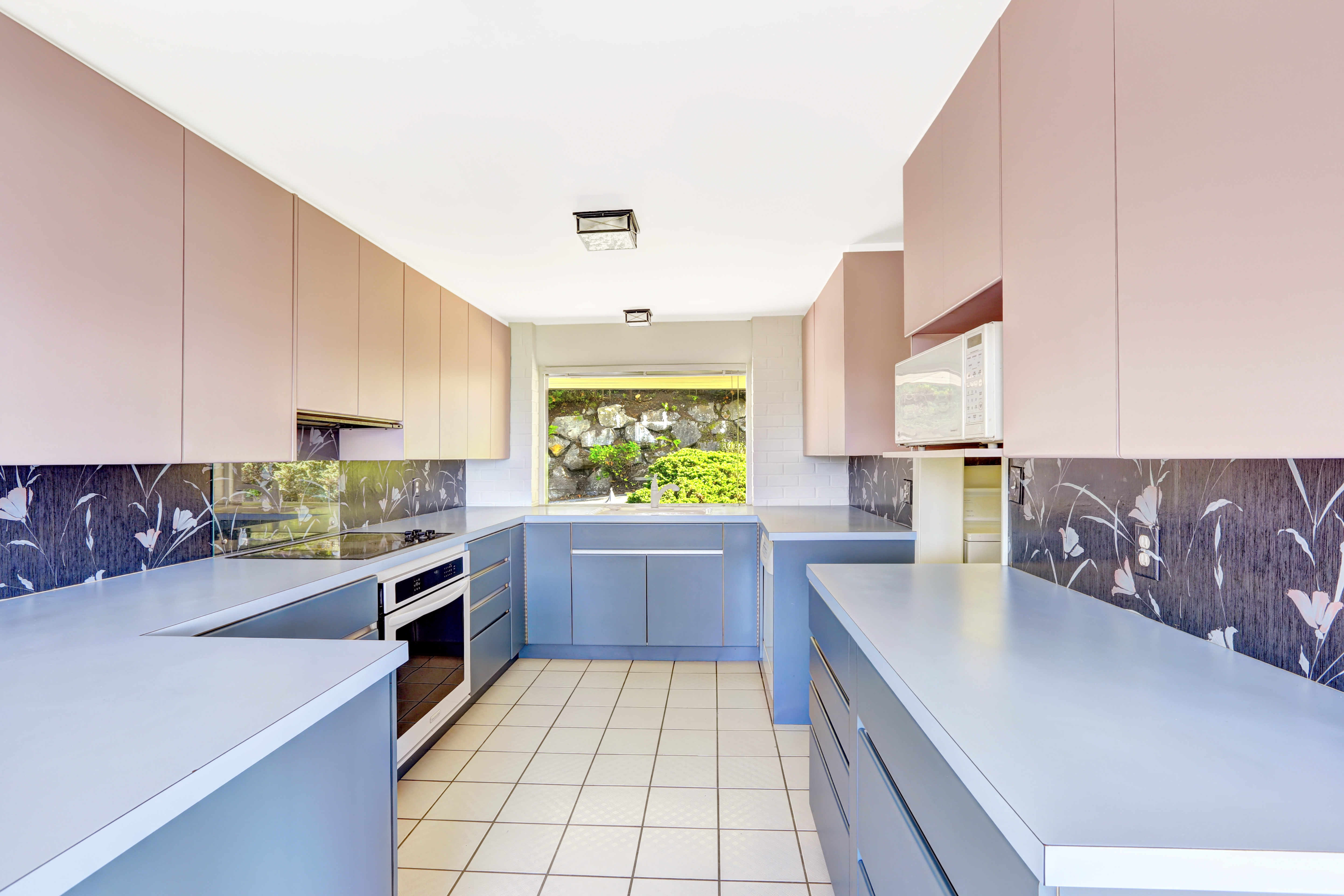 Kitchen with tile floor and pink and blue cabinets