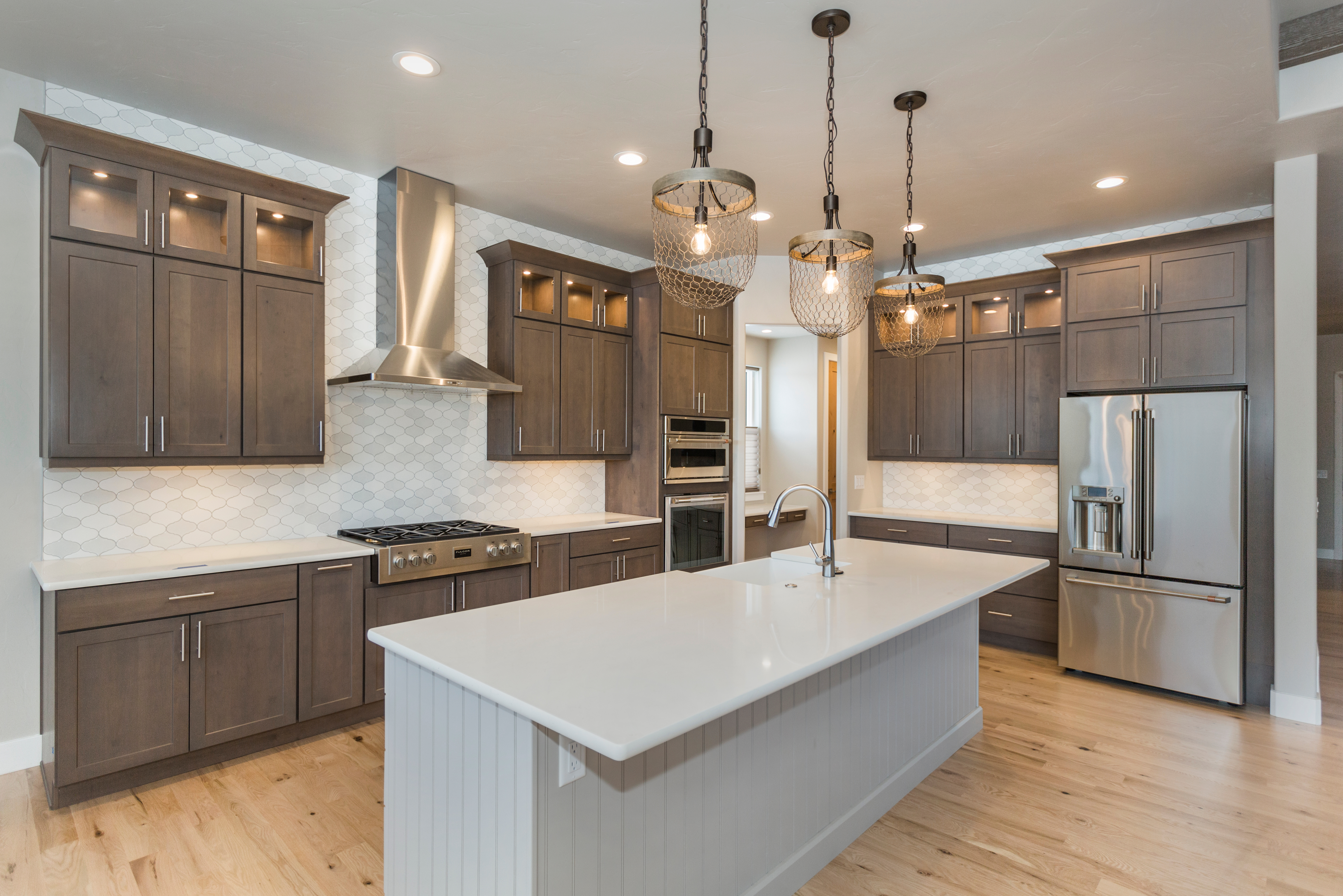 Luxury kitchen with island in center and taupe cabinets