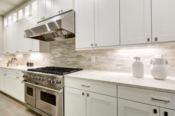 Luxury kitchen with white cabinets and stainless steel oven
