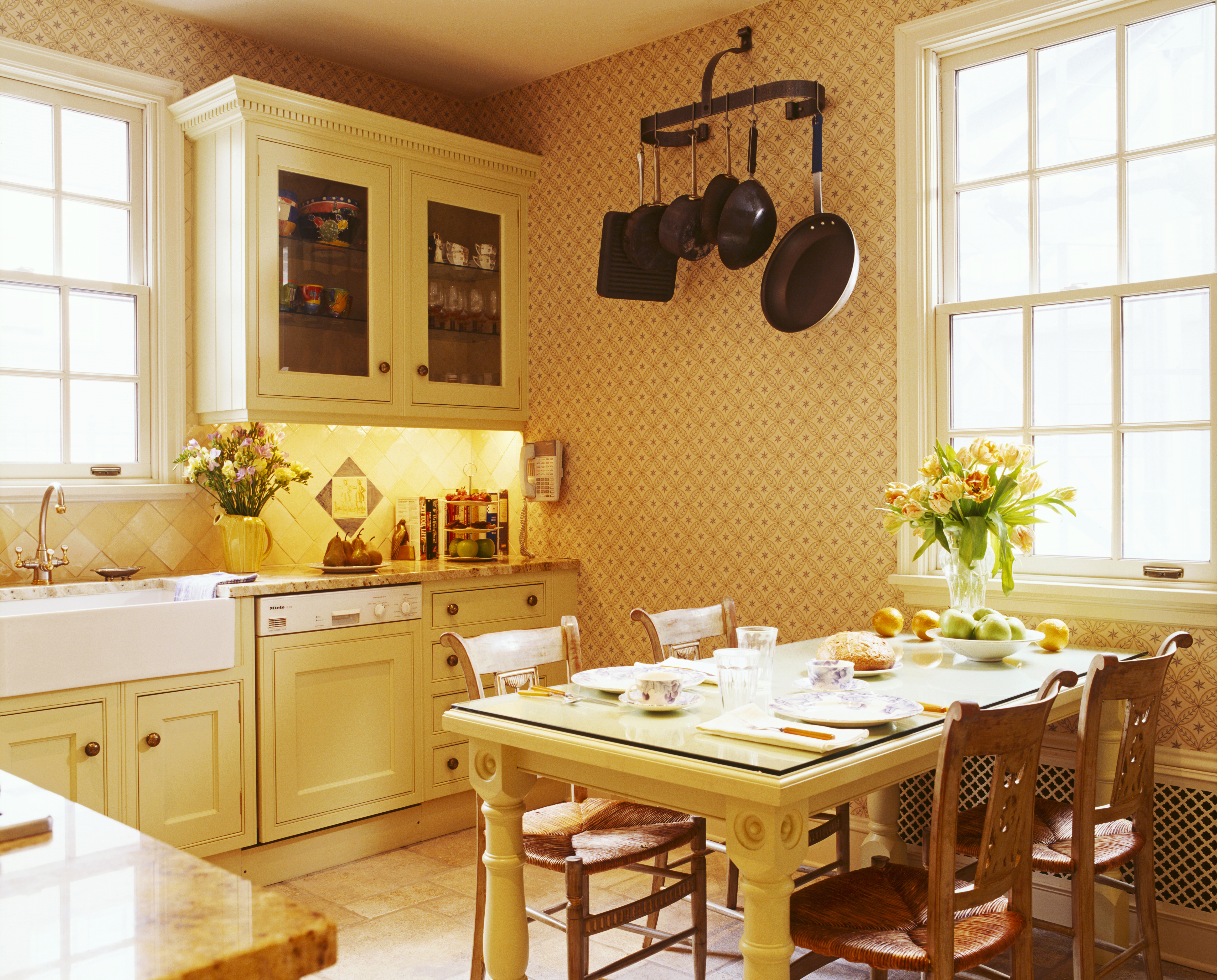 Traditionele landelijke keuken met stoelen met canestoel aan tafel