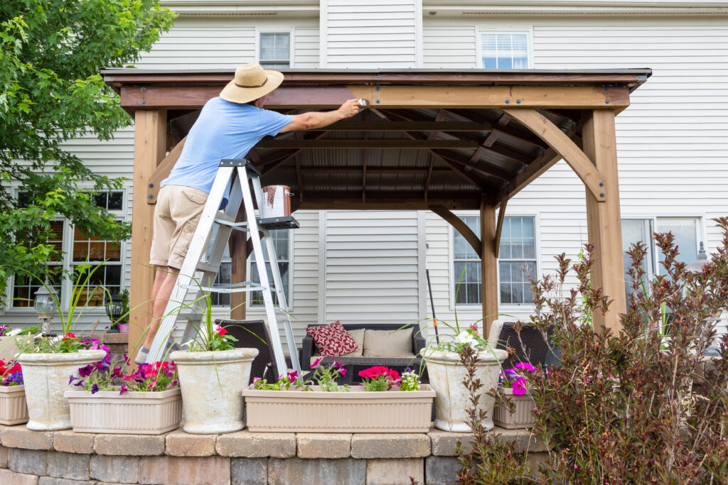 man painting pergola