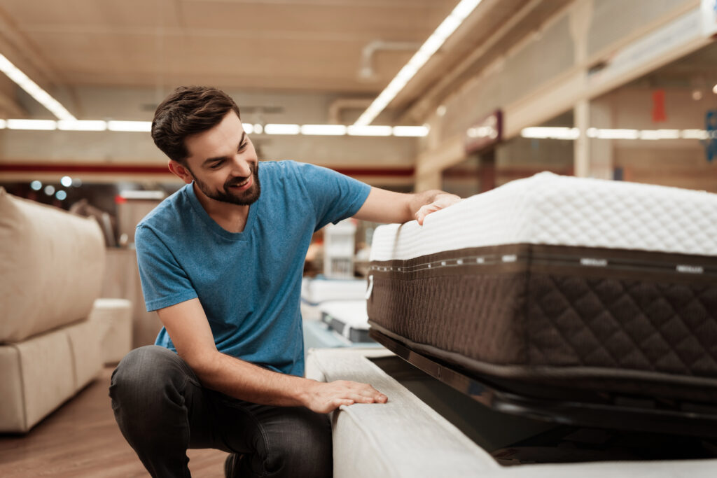 bearded man looking at mattresses