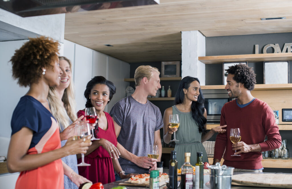 Group of friends in a kitchen preparing for a dinner party