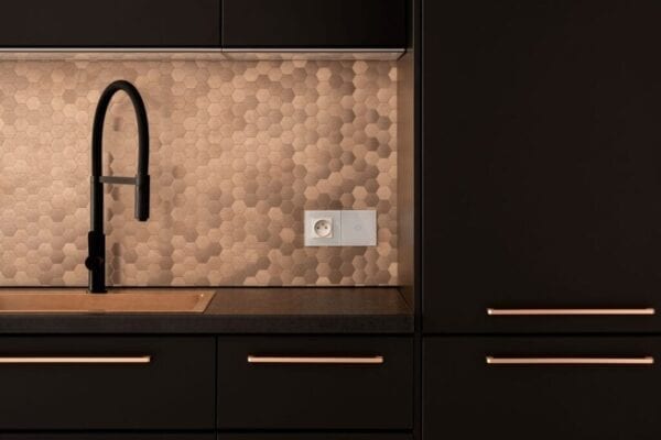 Kitchen with copper tile backsplash and black cabinets