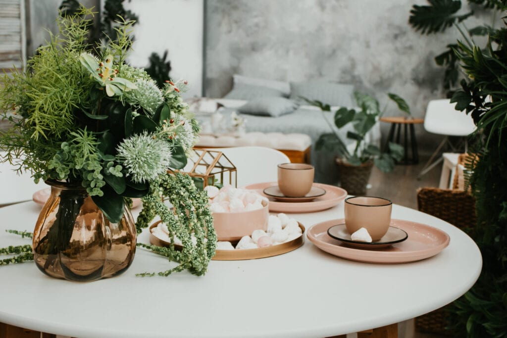 Luxurious bedroom interior with a tray with a cup, saucer, marshmallows and flowers on the table.