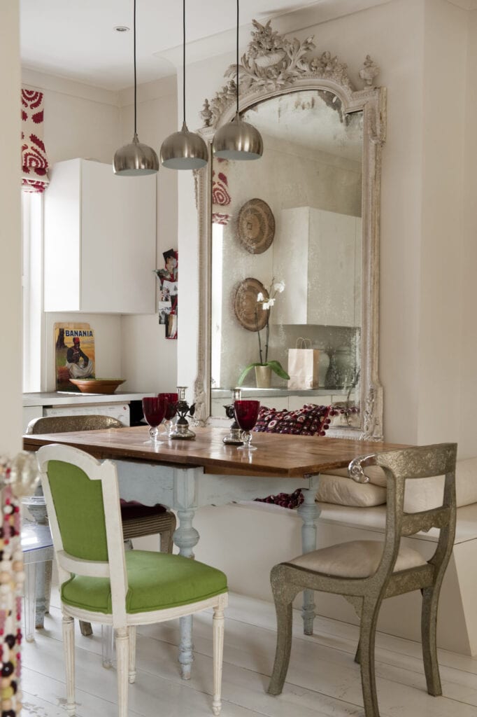 Dinging room with modern silver pendant lights, large french mirror and rams head chair from Graham and Green