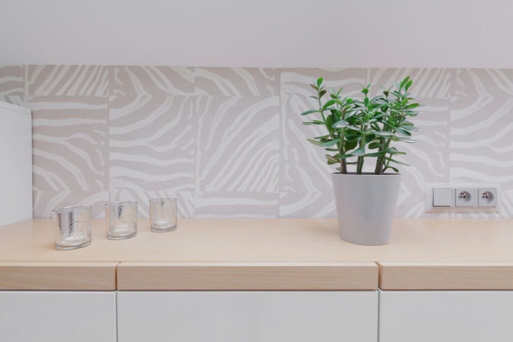 Close up of kitchen with wooden counter top and modern wallpaper patterned backsplash