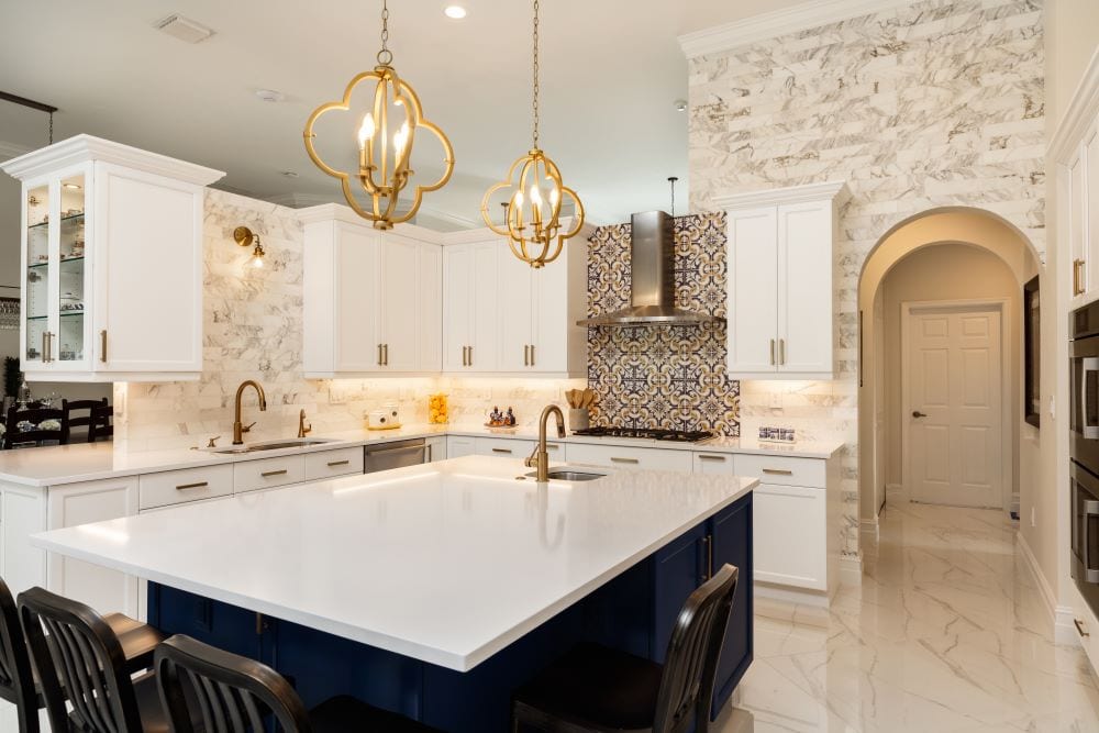 Luxury kitchen with floor-to-ceiling backsplash and gold pendant lights 