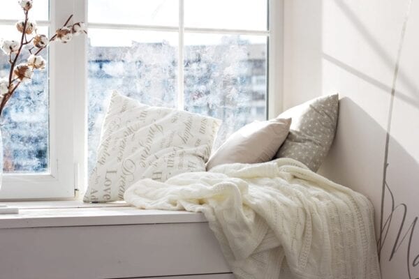 Cozy window seat with knit blankets in teen bedroom