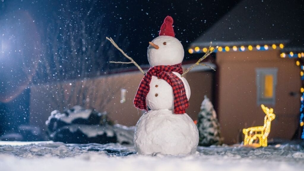 Snowman in yard at night