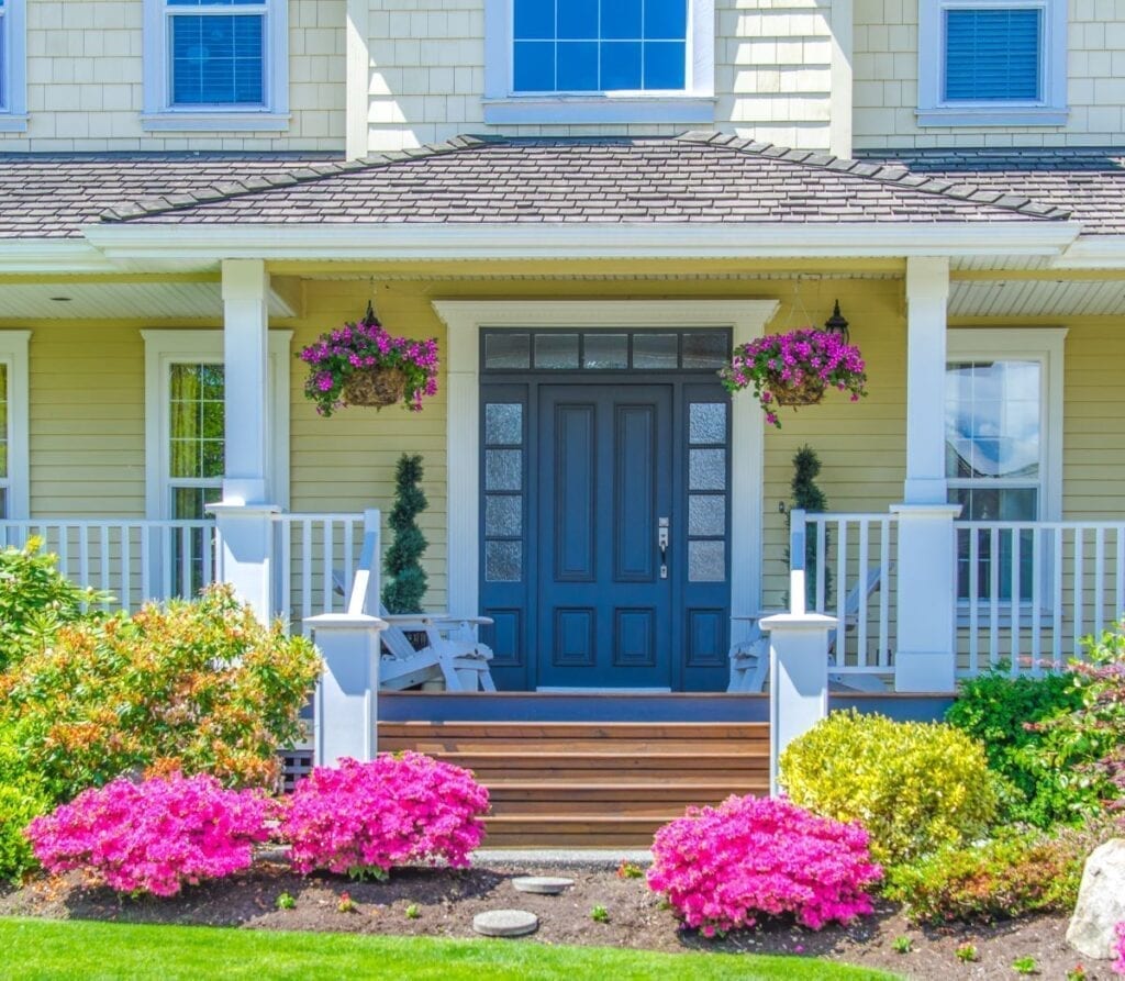 Entrance to house with beautiful landscaping and flowers