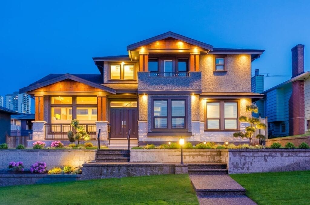 House with well lit landscaping at night