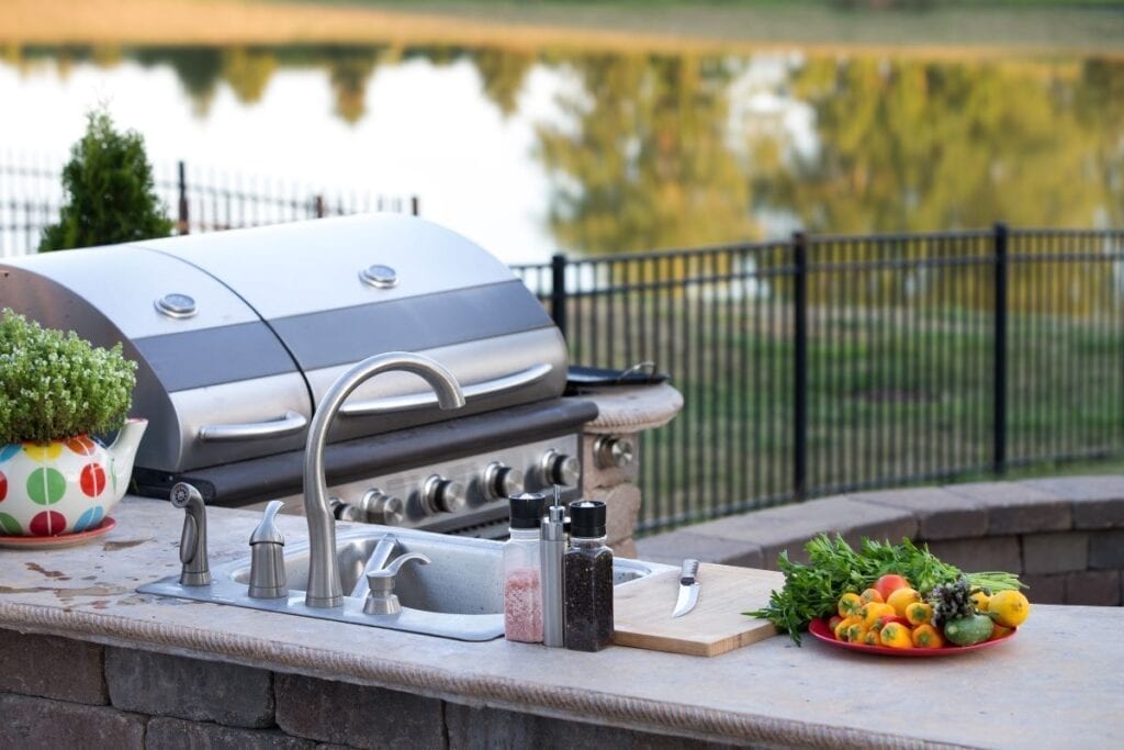 Outdoor kitchen with sink and grill in back yard