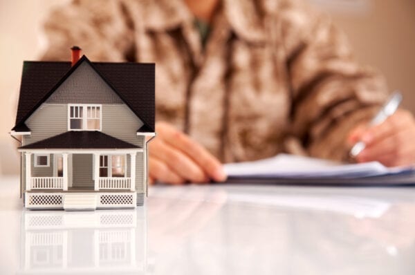 Service member wearing Marines uniform (MARPAT) filling real estate related paperwork.