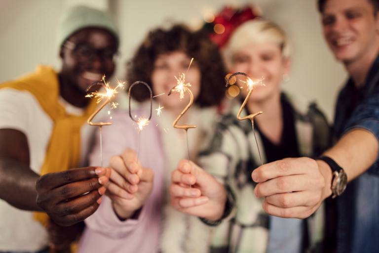 Group of 4 friends holding 2022 sparklers.