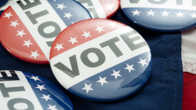 Vote election campaign button badges and the united states of american flag